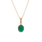 Gold necklace with a green emerald pendant on a white background